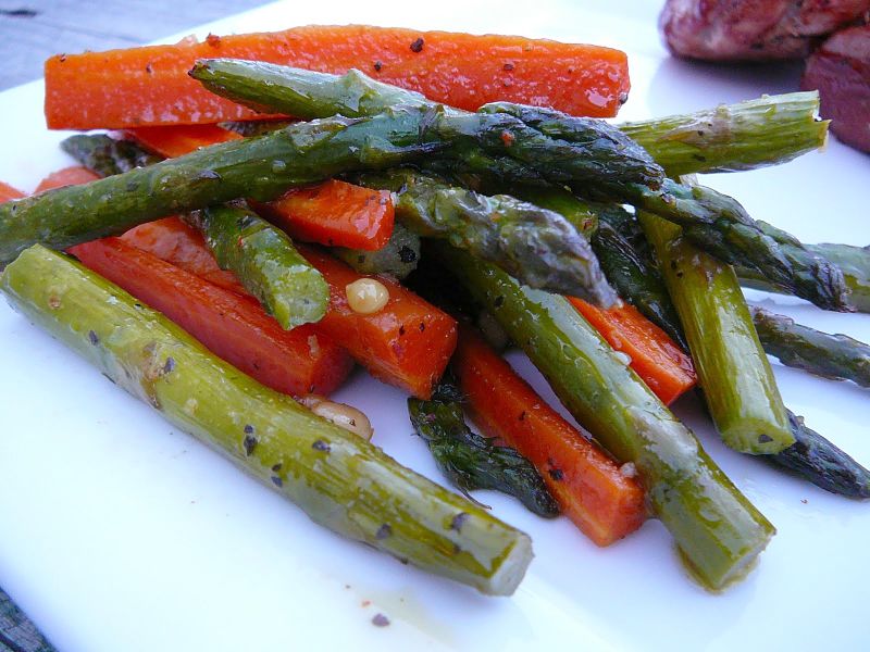 Grilled or barbecued asparagus is a delightful side dish accompanied by bell pepper strips